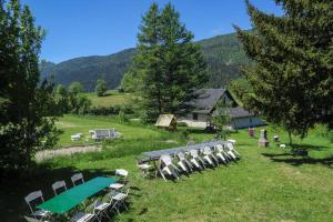 um grupo de cadeiras e uma mesa de piquenique num campo em Gîte SOLDANELLE - 15 personnes - "Les Gites du Chalet" à Autrans em Autrans