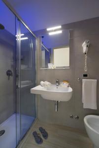 ein Bad mit einem Waschbecken und einer Dusche in der Unterkunft Hotel Pillon in Bibione