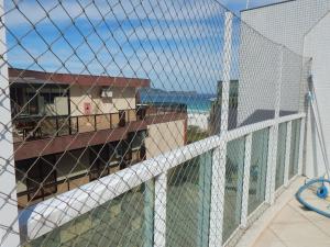 - Balcón con vistas a un edificio a través de una valla en Cobertura de Luxo com Piscina e churrasqueira na Praia do Forte, en Cabo Frío