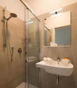 ein Bad mit einem Waschbecken und einer Glasdusche in der Unterkunft Hotel Pillon in Bibione