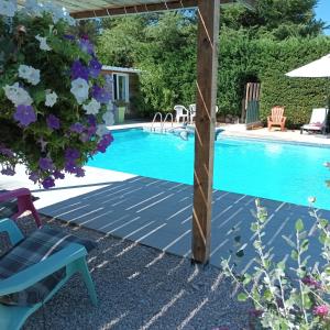 a swimming pool with a pergola next to a house at Chalet banane devant piscine, a 6km du festival de piano de la roque d'anthéron in Rognes