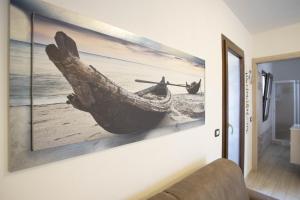 a painting of a boat on a wall at You and Me apartment in Isola Rossa
