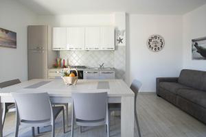 イーゾラ・ロッサにあるYou and Me apartmentのテーブルと椅子のあるキッチンとリビングルーム