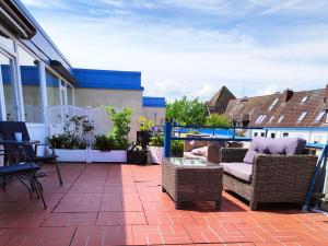 eine Terrasse mit Korbstühlen und einem Glastisch in der Unterkunft Ferienwohnung Kassiopeia in Laboe