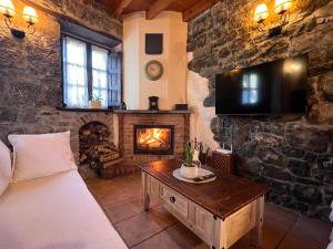 a living room with a bed and a fireplace at casa rural casa cerezal in Cangas de Onís