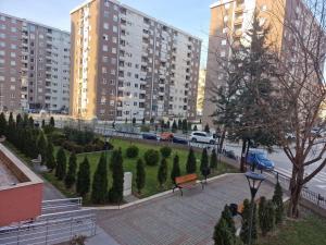 Blick auf einen Park mit Bäumen und Gebäuden in der Unterkunft Luxury Green & Modern Apartment in Skopje