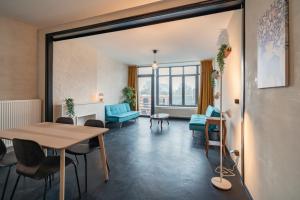 een woonkamer met een tafel en stoelen en een tafel bij Charming and Spacious Antwerp City Center Apartments in Antwerpen