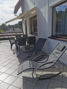 a pair of chairs and tables on a balcony at Villa Lounika in Warnowo