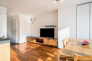 a living room with a table and a flat screen tv at Kilian in Schwarzach