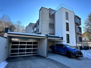 un garaje con un coche azul estacionado frente a un edificio en Planai Apartment Eishöhle en Schladming