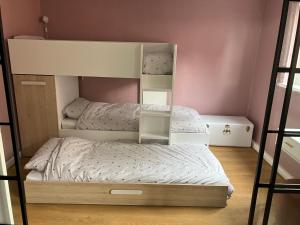 two bunk beds in a small room with pink walls at Lovely family seafront property in Burnham-on-Sea in Burnham on Sea