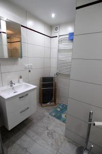 a white bathroom with a sink and a mirror at Villa Lounika in Warnowo +13 photos