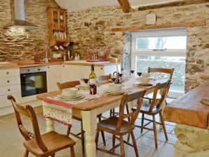 a kitchen with a table with chairs and a bottle of wine at Swallow Lodge in Mathry