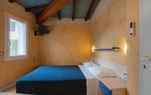 a small bedroom with a bed and a window at Park Gallanti in Lido di Pomposa