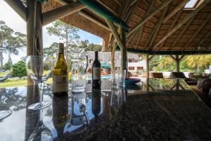 a table with wine bottles and glasses on it at Plotsklaps Self Catering Cottage in Tokai