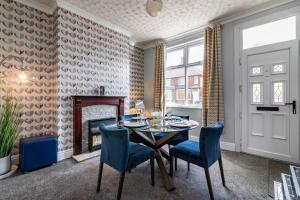 uma sala de jantar com uma mesa e cadeiras azuis em Breedon House 2 Bedroom Home in Long Eaton close to AIRPORT em Long Eaton