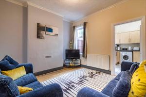 a living room with a blue couch and a tv at 2 bed House sleeps 4 Long Eaton Nottingham Free parking Breedon in Long Eaton