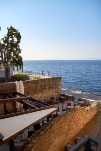 una fila di tavoli e sedie accanto all'oceano di ApartmentsGarda - Residenza Dei Navigatori a Torri del Benaco