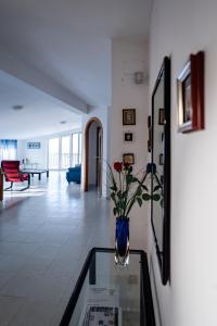 a living room with a vase with flowers on a glass table at La Casa del Maestro Attico in Pisciotta