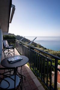 d'un balcon avec une table et des chaises donnant sur l'océan. dans l'établissement La Casa del Maestro Attico, à Pisciotta