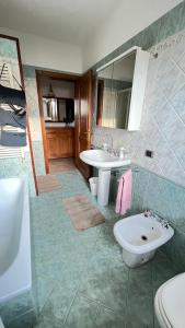 een badkamer met een wastafel, een toilet en een spiegel bij Casa Piera in Pietrasanta