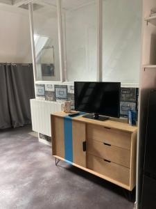 a television on a wooden stand in a room at Logis côté Cour in Varennes-lès-Narcy