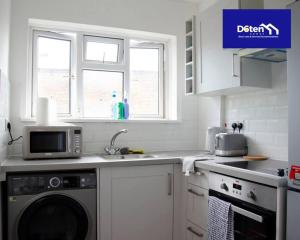 a kitchen with a washing machine and a microwave at Sleeps 7x Weekly, Monthly Discounts x Free Parking in Forest Hill