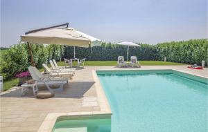 a swimming pool with umbrellas and chairs and a swimming pool at Casale Delle Rose in Lendinara