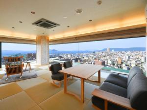 a living room with a table and a large window at Yunaginoyu Hotel Hanajyukai in Takamatsu