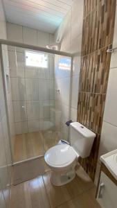 a bathroom with a white toilet and a shower at Cantinho do sossego in Blumenau