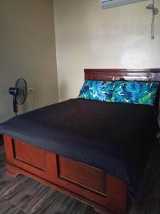 a bedroom with a bed with a wooden head board at Portofino Homestay in Malitbog