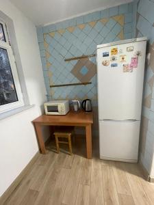 uma cozinha com um frigorífico e uma mesa com um micro-ondas em One Bedroom Apartment Near Buyuk Ipak Yuli Metro Station, Located in Downtown em Tashkent