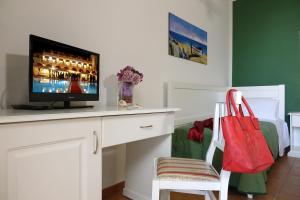 Camera con scrivania, TV e borsa rossa. di LEUCA TWENTY ROOMS a Leuca