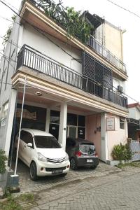 two cars parked in front of a building at Ganeta Homestay Syariah in Kalangan