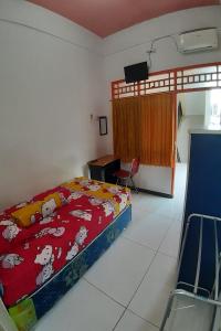 um quarto com uma cama e uma secretária. em Ganeta Homestay Syariah 
