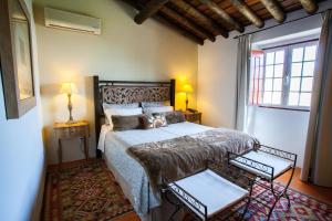 a bedroom with a bed and two lamps and a window at Herdade de Agua D' Alte in Redondo