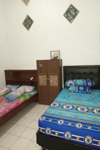 two beds sitting next to each other in a bedroom at Ganeta Homestay Syariah in Kalangan +32 photos
