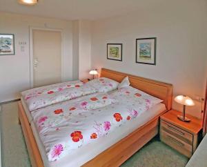 ein Schlafzimmer mit einem Bett mit Blumen darauf in der Unterkunft Haus Kees - Wohnung 1 in Kressbronn am Bodensee