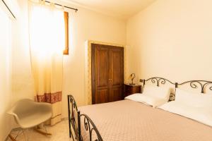 a bedroom with a bed and a chair and a window at Agriturismo Il Giglio in Oristano