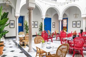 un restaurante con sillas rojas y mesas en un edificio en Vincci Molviedro Suites Apartments, en Sevilla