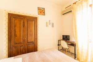 a bedroom with a wooden door and a desk with a computer at Agriturismo Il Giglio in Oristano