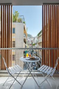 a table and chairs on a balcony with a view at Trikoupi 95 by ABR in Athens