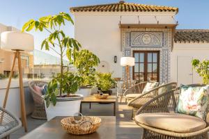 a patio with chairs and a table with plants at Vincci Molviedro Suites Apartments in Seville