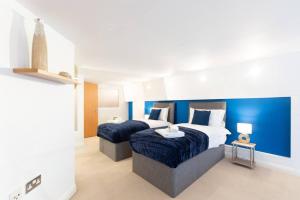 a bedroom with two beds and a blue wall at Crusader Apartment (Notts City Centre Central) in Nottingham