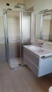 bagno con doccia, lavandino e specchio di B&B LA DEA LUMACA a Villareggia