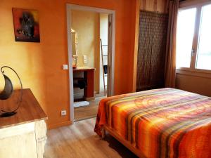 Schlafzimmer mit einem Bett, einem Schreibtisch und einem Fenster in der Unterkunft mas des broussonnetiers in Barjac