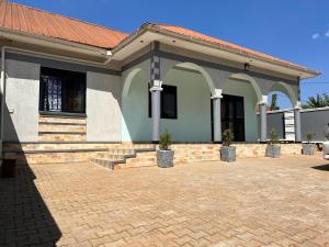a house with a brick driveway in front of it at Beautiful family House in Kasiyirize