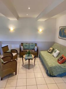 Habitación con 2 camas, sofá y silla en Gîte - Le Relais d'Affiac, en Peyriac-Minervois