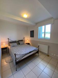 1 dormitorio con cama y ventana. en Gîte - Le Relais d'Affiac, en Peyriac-Minervois