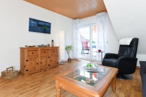 Sala de estar con silla negra y mesa en Ferienwohnungen Haus Wiesen- und Waldblick, en Esens